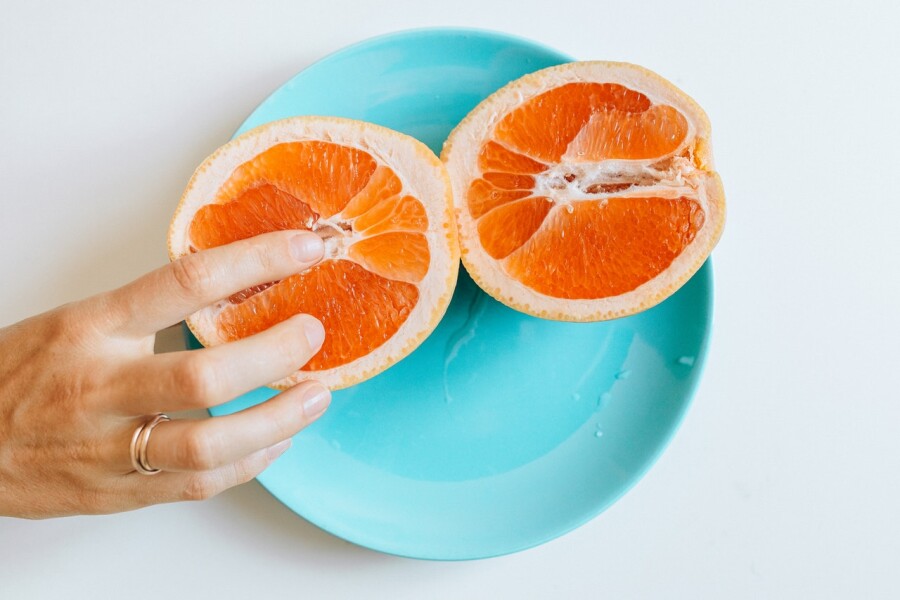 палец на половинке апельсина