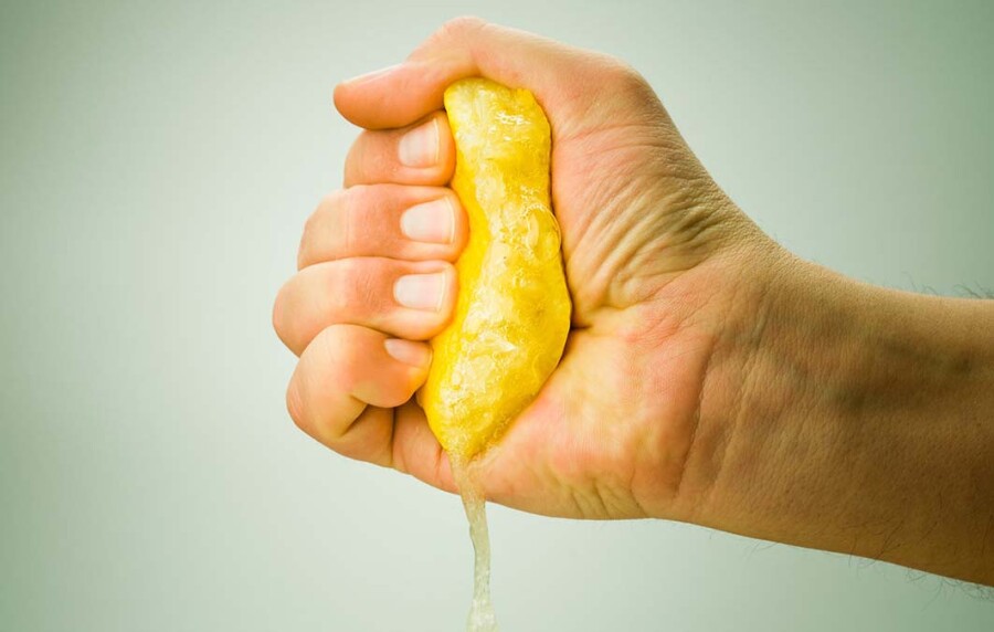 рука сжимает лимон