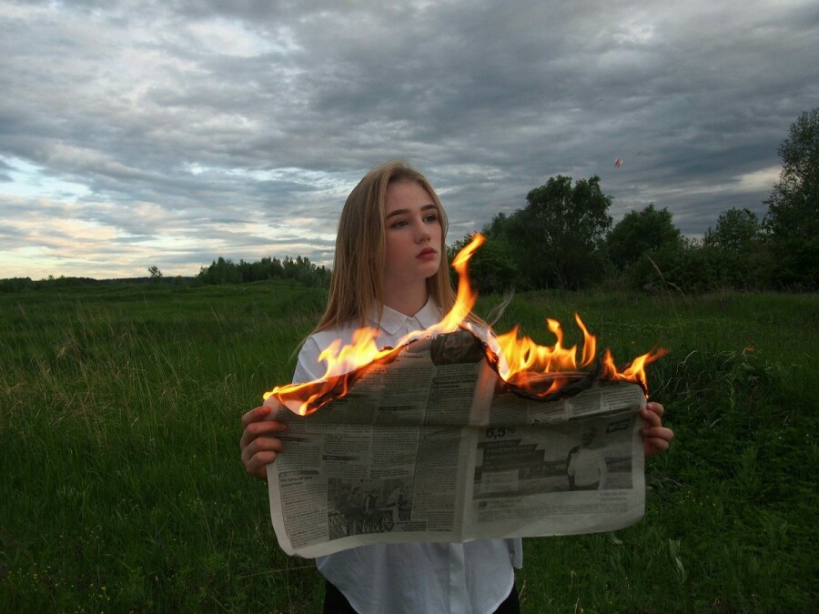 девушка сжигает газету