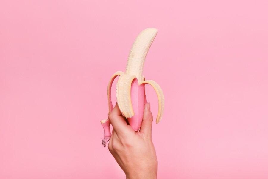 розовый банан в руке