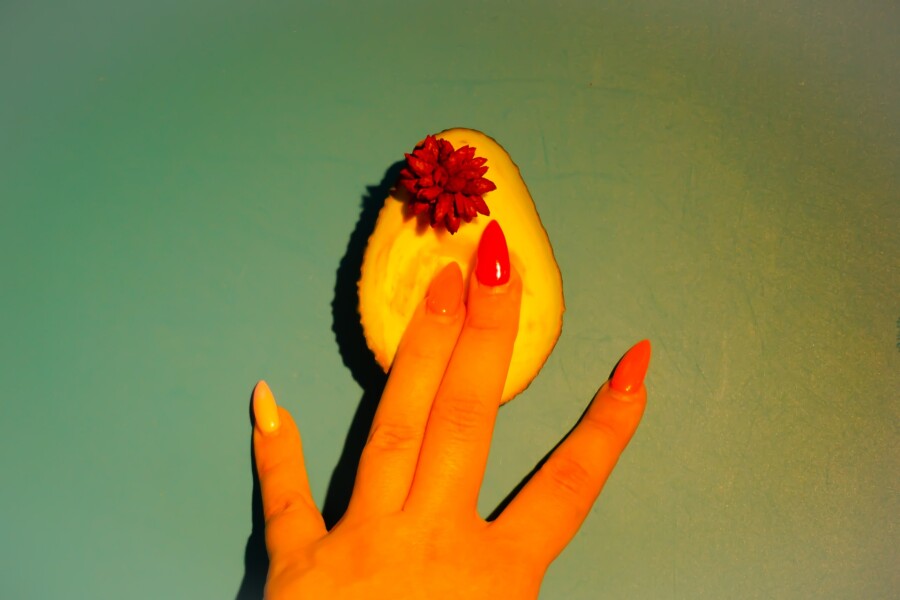 пальцы на половинке авокадо