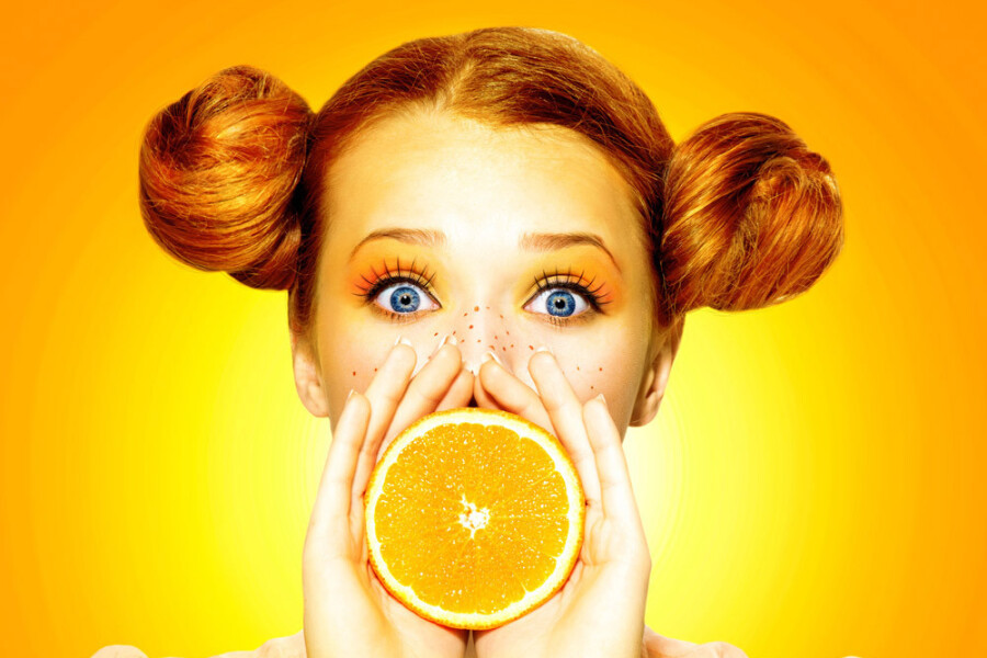 девушка с апельсином у рта