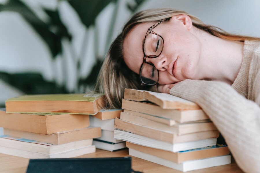 девушка спит на книгах