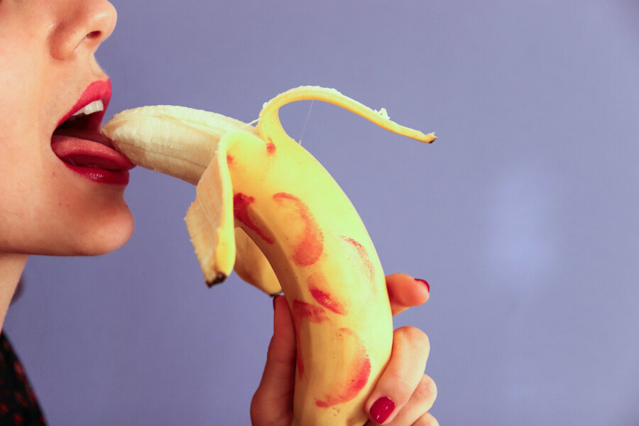 девушка облизывает банан