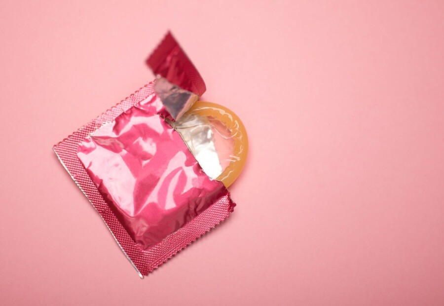 презерватив на розовом фоне