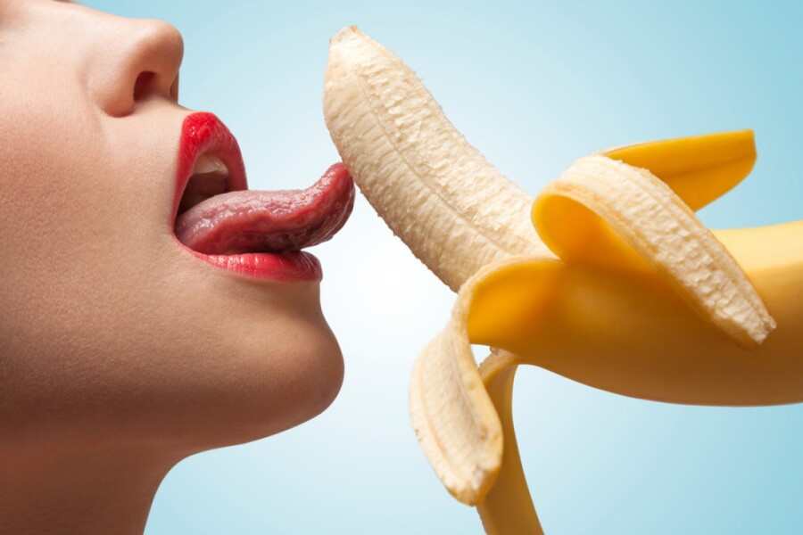 девушка облизывает банан
