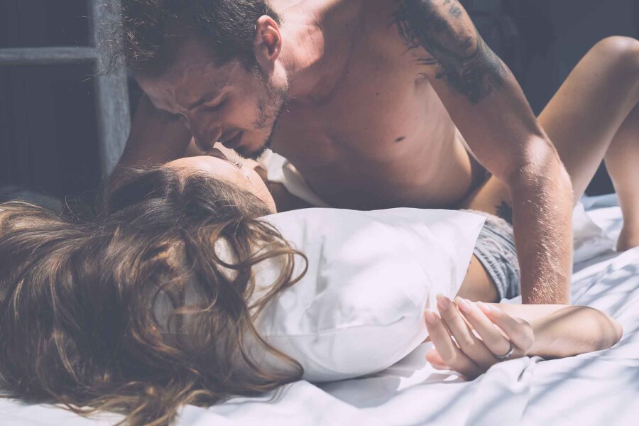 страстная пара целуется в постели