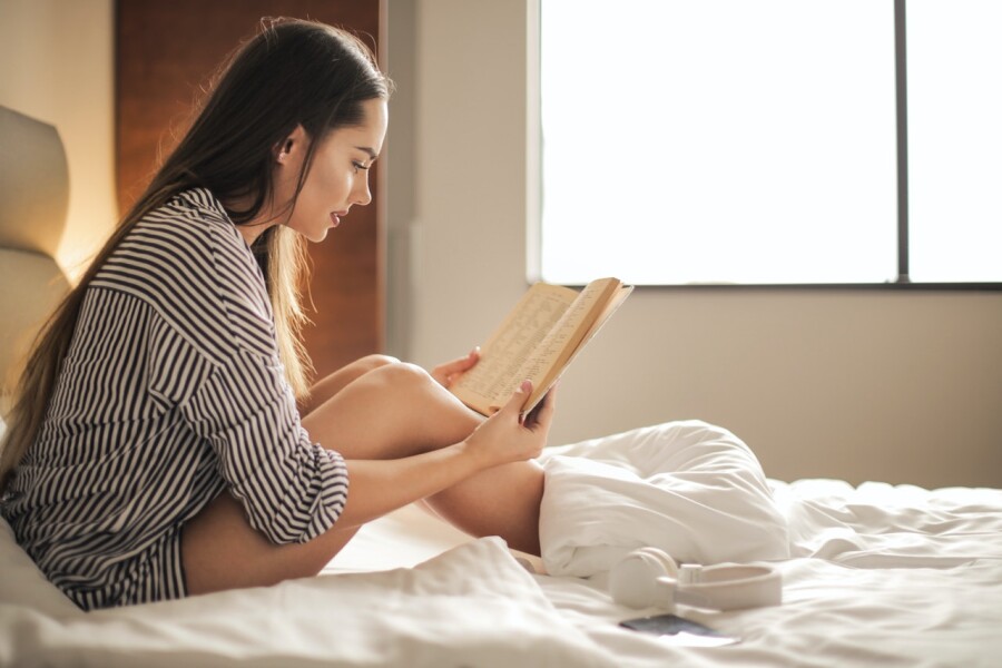 девушка на кровати с книгой