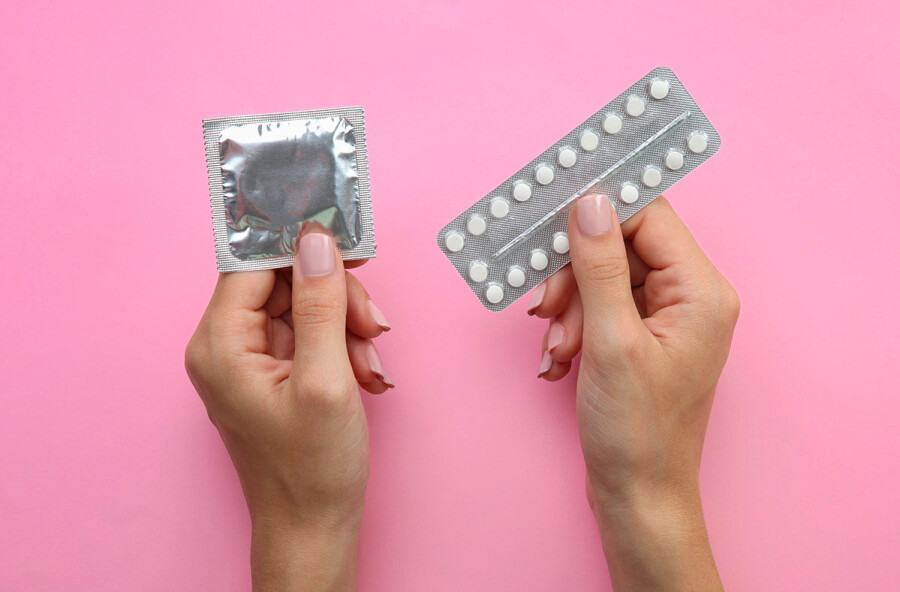 презерватив и таблетки в руках
