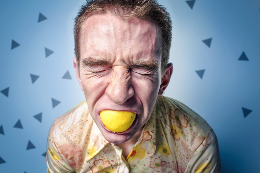 мужчина с лимоном во рту