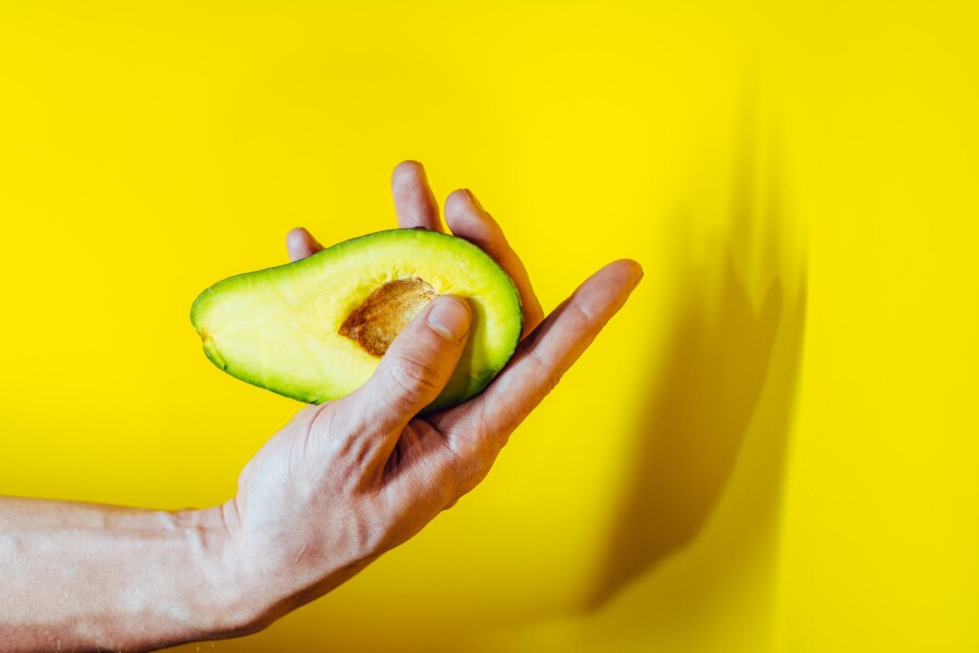половинка авокадо в руке