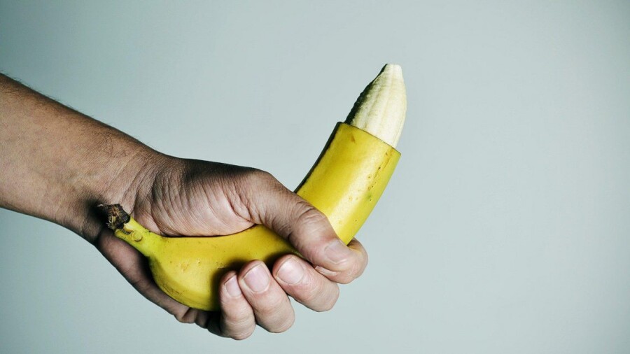 парень держит банан в руке