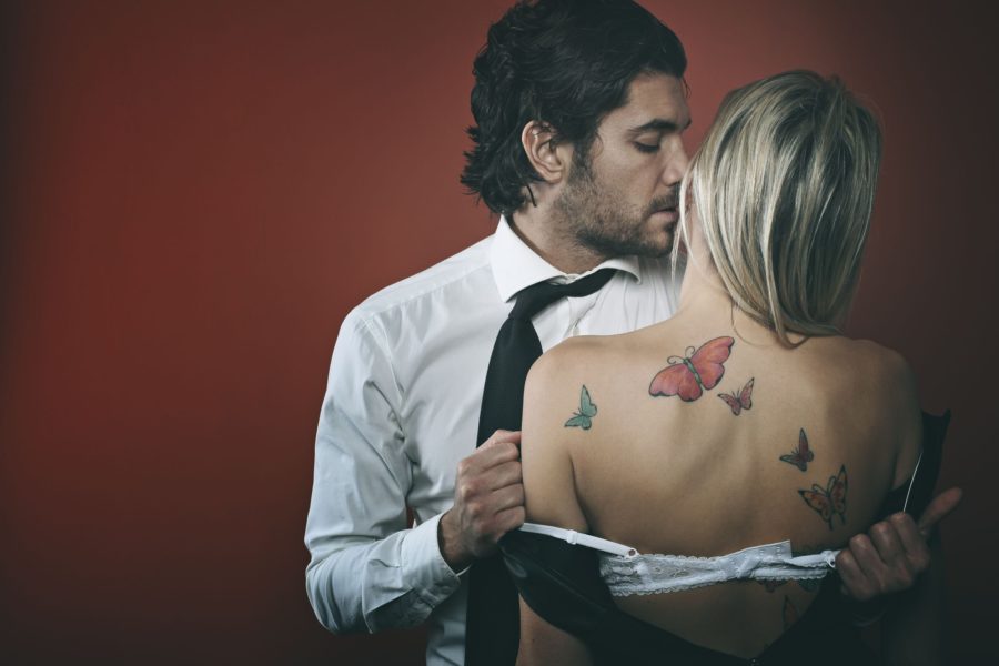 Handsome fashion man undressing woman