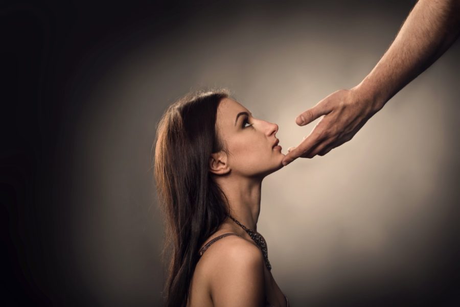 Male hand touches to woman face as Sexual Harassment