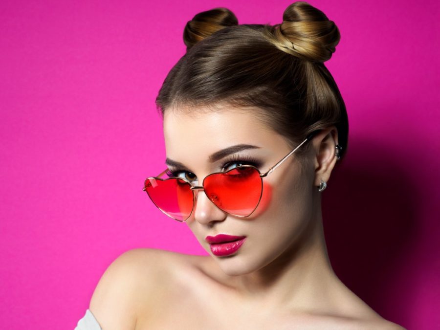 девушка на розовом фоне в очках