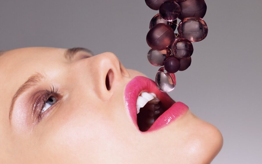 девушка облизывает виноград