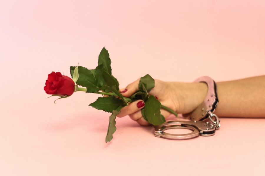 роза в руке с наручниками